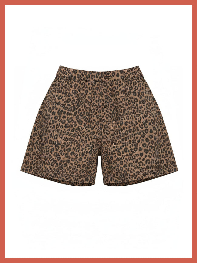 A pair of leopard print shorts in brown and black, displayed flat against a white background with a coral border.