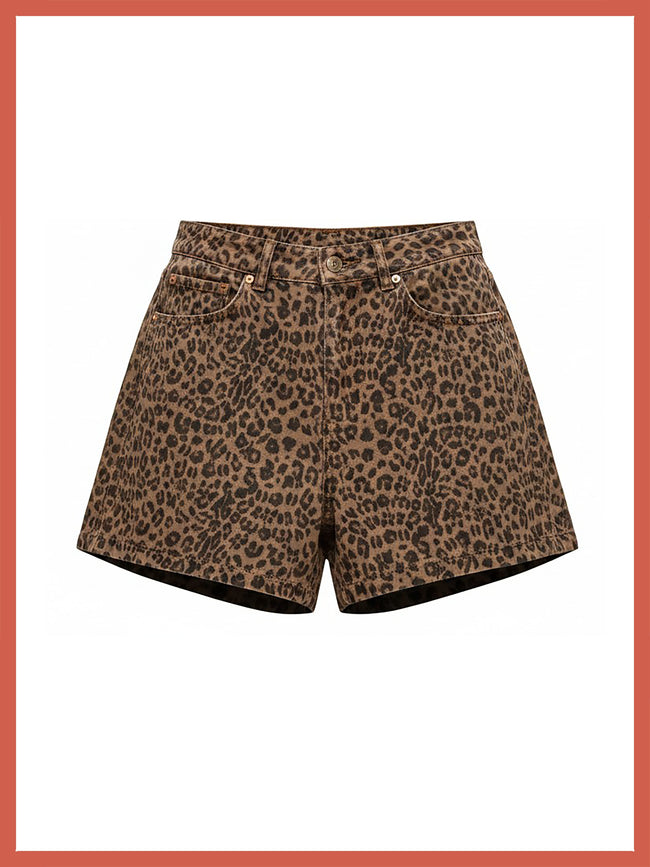 A pair of leopard print shorts in brown and black, featuring a classic five-pocket design and a button closure, shown against a white background with a coral border.