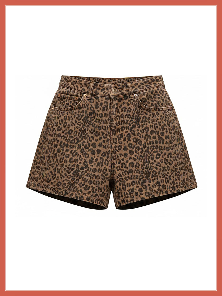 A pair of leopard print shorts in brown and black, featuring a classic five-pocket design and a button closure, shown against a white background with a coral border.